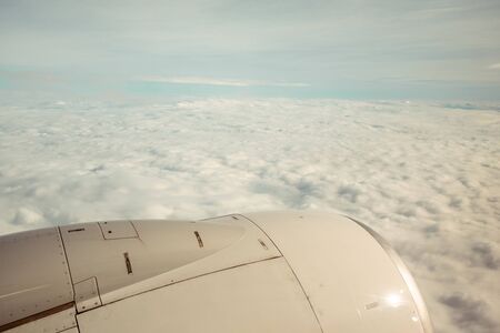 view of the wing of an airplane during the flight with a very cloudy dayの写真素材