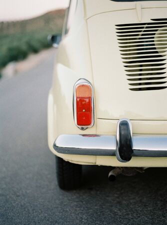 detail of a headlight on the back of a yellow classic carの写真素材