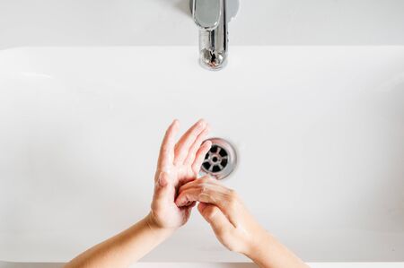 boy washing his hands after playing to fight the coronavirusの写真素材