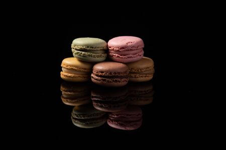 macaroons isolated in reflective black backgroundの写真素材