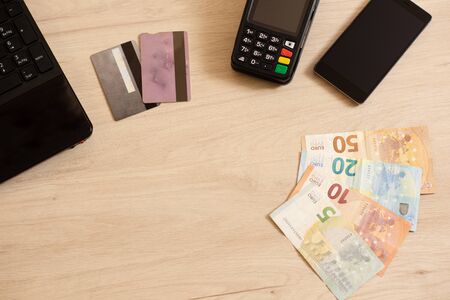 Polish currency money and credit card with payment terminal in background, paying using credit card or cash, finance and banking conceptの写真素材