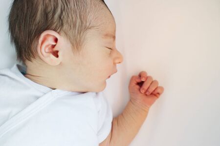 Close up newborn baby. First minutes of life. Newborn baby wrapped in the bedsheet of the hospitalの写真素材