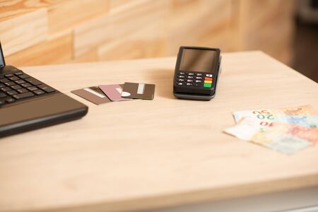 Polish currency money and credit card with payment terminal in background, paying using credit card or cash, finance and banking conceptの写真素材