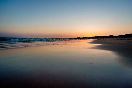 sunset on a beach in huelva in summer. The sun is reflected on the seashoreの写真素材