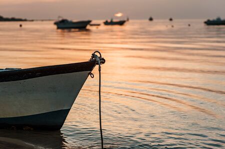 A small boat in a beach in cadiz at sunsetの写真素材