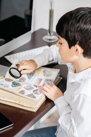 Child holding a magnifying glass and a bookの写真素材