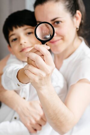 happy mother and son looking through a magnifying glassの写真素材