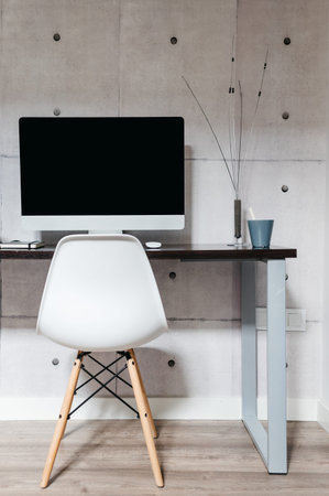 A desk with a computer on a table. Minimalist work zone