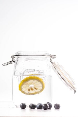 transparent water bottle with lemon slice falling at high speedの写真素材