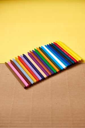 multi-colored pencils on a yellow and brown cardboardの写真素材