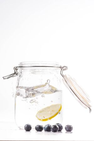 transparent water bottle with lemon slice falling at high speedの写真素材