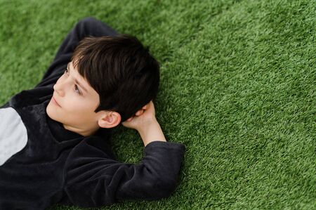 A little boy that is sitting in the grassの写真素材