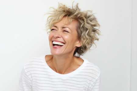 Happy middle-aged woman laughing and looking up on white backgroundの素材