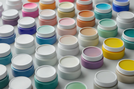 A row of colorful jars of paint. The jars are of different colors and sizes, and they are arranged in a neat row. The jars are likely to be used for painting or art projectsの素材