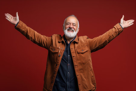 A man in a brown jacket is smiling and raising his arms. Concept of happiness and warmthの素材