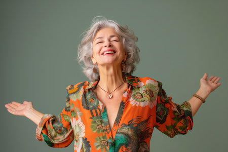 A woman in a floral print shirt is smiling and waving. She is wearing a necklace and earringsの素材