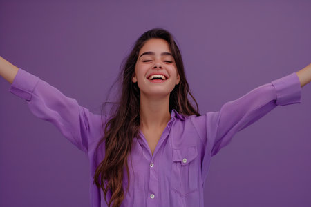 A woman is smiling and wearing a purple shirt. She is happy and content. Concept of joy and positivityの素材