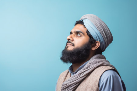 A man with a beard and turban is looking up at the sky. Concept of contemplation and introspectionの素材