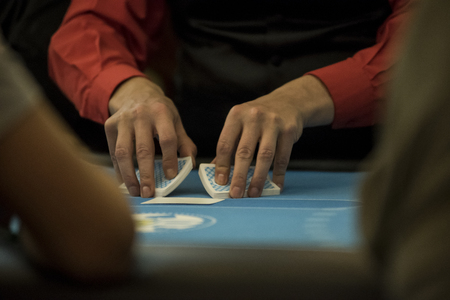 A croupier shuffles the cards in a poker tableのeditorial素材