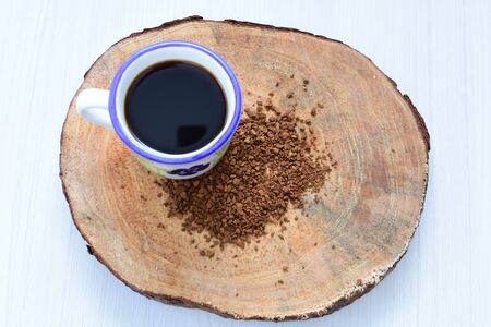 Cup of coffee, accompanied by coffee beans on wooden backgroundの写真素材