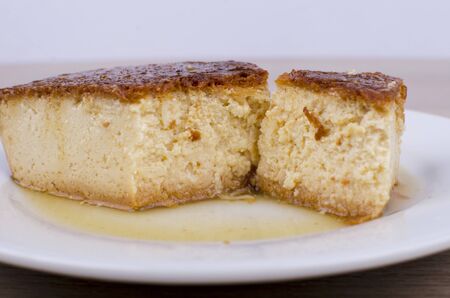 Caramel custard and a lot of sweet sauce on wooden backgroundの写真素材