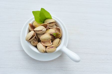 Whole, dried, open, whole, shelled and chopped dried pistachios displayed in containersの写真素材