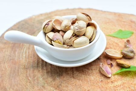 Whole, dried, open, whole, shelled and chopped dried pistachios displayed in containersの写真素材