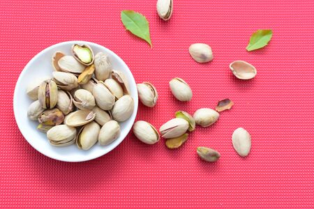 Whole, dried, open, whole, shelled and chopped dried pistachios displayed in containersの写真素材