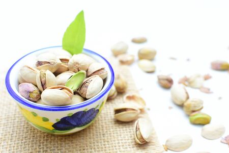 Whole, dried, open, whole, shelled and chopped dried pistachios displayed in containersの写真素材