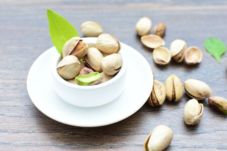 Whole, dried, open, whole, shelled and chopped dried pistachios displayed in containersの写真素材