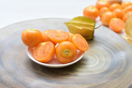 fresh whole gooseberries, shelled and sliced, displayed in containersの写真素材