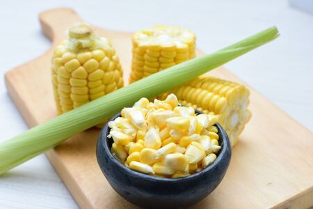 yellow sweet corn (cob) and green husk, chopped and shelled cornの写真素材