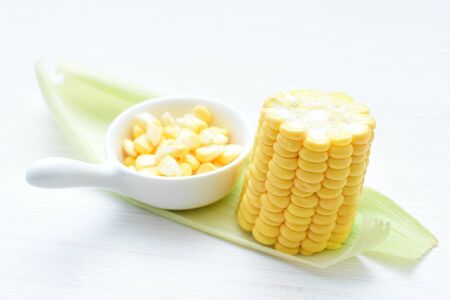 yellow sweet corn (cob) and green husk, chopped and shelled cornの写真素材