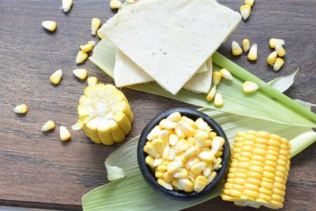 yellow sweet corn (cob) and green husk, chopped and shelled cornの写真素材