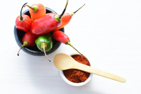 Capsicum Red and green and yellow bell peppers and chili peppers, displayed watered on a wooden...