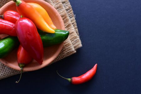 Capsicum Red and green and yellow bell peppers and chili peppers, displayed watered on a wooden surfaceの写真素材