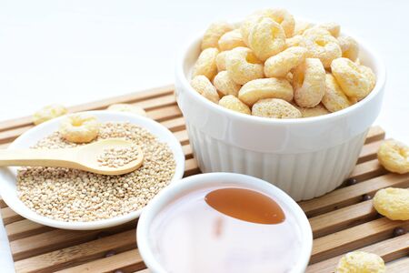 Quinoa cereal accompanied by quinoa seeds and honey on a light backgroundの写真素材