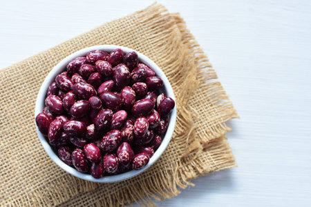 (Phaseolus vulgaris) Red beans displayed in different containers on flat bottoms