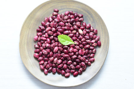 (Phaseolus vulgaris) Red beans displayed in different containers on flat bottoms