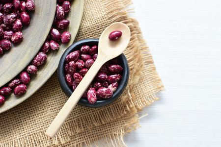 (Phaseolus vulgaris) Red beans displayed in different containers on flat bottoms