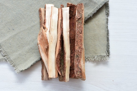 wooden sticks - firewood, placed on a tidy and cluttered flat surface on white wooden backgroundの写真素材