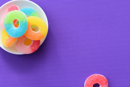Multicolored candy jelly beans, red, yellow, green, blue displayed in containers on white wooden...