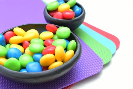 Variety of blue, red, green, yellow multicolored candies displayed in containersの写真素材