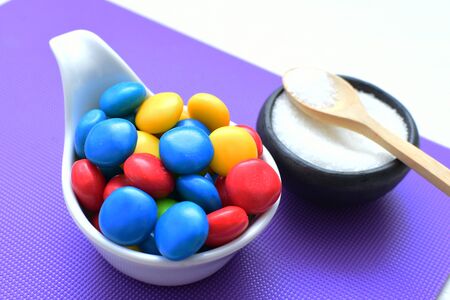 Variety of blue, red, green, yellow multicolored candies displayed in containersの写真素材
