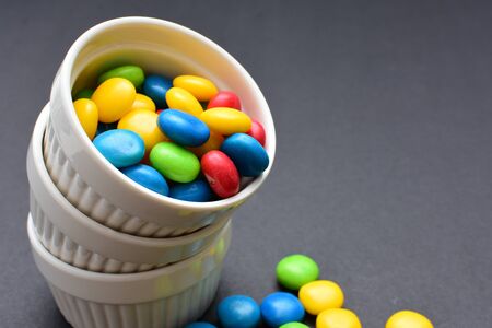 Variety of blue, red, green, yellow multicolored candies displayed in containersの写真素材