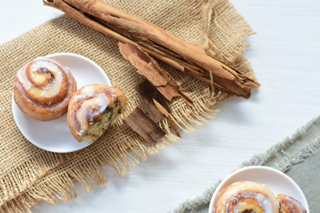 Delicious homemade small cinnamon rolls with melted sugar on light backgroundの写真素材