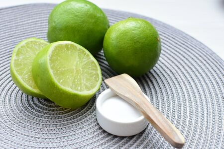 (Citrus - latifolia, the Persian lemon, whole and in pieces tahiti lemons accompanied by salt with an intense greenの写真素材