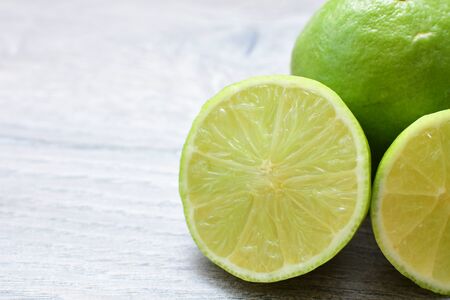 (Citrus - latifolia, the Persian lemon, whole and in pieces tahiti lemons accompanied by salt with an intense greenの写真素材