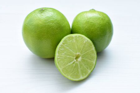 (Citrus - latifolia, the Persian lemon, whole and in pieces tahiti lemons accompanied by salt with an intense greenの写真素材