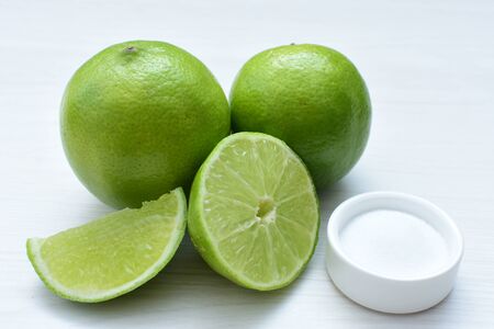 (Citrus - latifolia, the Persian lemon, whole and in pieces tahiti lemons accompanied by salt with an intense greenの写真素材